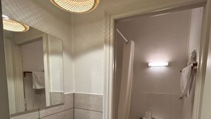 Une salle de bain moderne avec un lavabo, un miroir et des toilettes, le tout de couleur blanche.