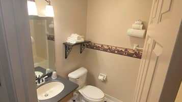 A bathroom with a toilet, sink, and towel rack.