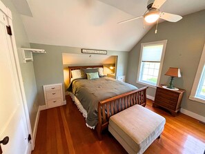 Makuuhuoneessa on sänky, yöpöytä, lipasto, ikkuna ja kattotuuletin.