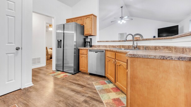 A modern kitchen with wooden cabinets, stainless steel appliances, and a granite countertop. - Warm & Charming 4-BR in the Heart of Southaven-Near Stateline, Silo Square. (Southaven)
