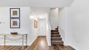 A hallway with wooden flooring, a staircase, and framed artwork on the walls. - Warm & Charming 4-BR in the Heart of Southaven-Near Stateline, Silo Square. (Southaven)