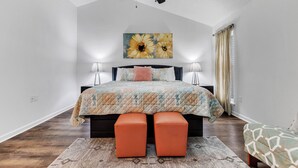 A bedroom with a bed, two bedside lamps, a ceiling fan, a large floral artwork, and a window with curtains. - Warm & Charming 4-BR in the Heart of Southaven-Near Stateline, Silo Square. (Southaven)