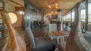 L’intérieur d’un restaurant avec des planchers en bois, des meubles modernes et de grandes fenêtres.