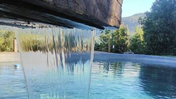 A clear pool with a waterfall feature.