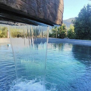 Een helder zwembad met een waterval.