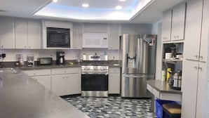 A modern kitchen with a central island, built-in appliances, and a skylight.