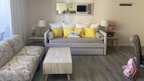 A living room with a grey sofa, a wooden coffee table, and a patterned sofa. - Lovely 1-bedroom w/ocean view, WiFi, AC & FREE Parking (Honolulu)