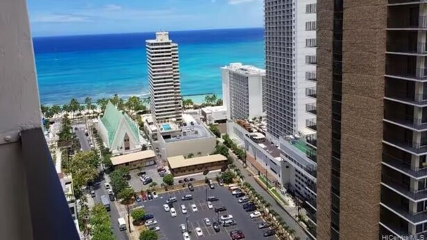 A high-rise hotel with a view of the ocean and a parking lot. - Lovely 1-bedroom w/ocean view, WiFi, AC & FREE Parking (Honolulu)