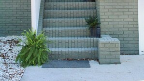 A house with a front porch, steps, and a door. - Entire Home Direct River Access Momma Marie’s (Spring Hill)