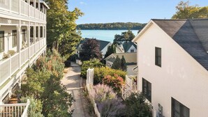 Un quartier résidentiel avec un sentier menant à un lac, entouré de maisons dotées de balcons et offrant une vue sur l’eau.