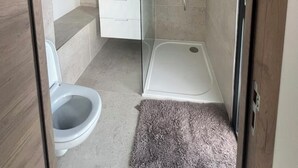 Un baño moderno con ducha, inodoro y lavamanos.