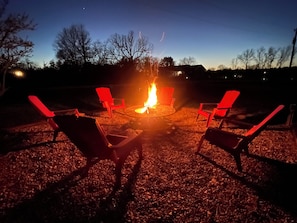 Relax in the outdoor seating area with a central fire feature and four comfortable chairs.