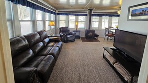 A living room with a leather sofa, a fireplace, a television, and a dining area with a table and chairs. - Large 3 Bedroom, 2 Bath Home, Premium Kitchen, Large Family & Living Rooms (Dayton)