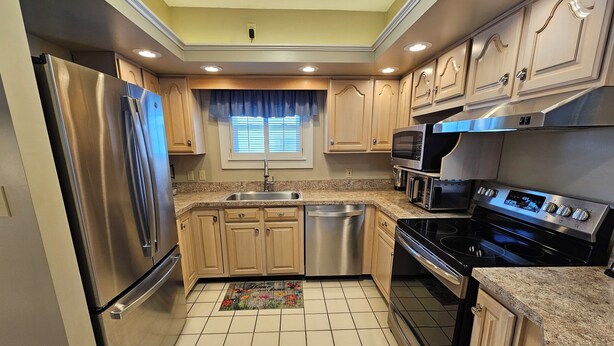 A modern kitchen with stainless steel appliances, wooden cabinets, and a tiled floor. - Large 3 Bedroom, 2 Bath Home, Premium Kitchen, Large Family & Living Rooms (Dayton)