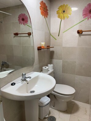 A bathroom with a sink, toilet, and mirror. - Los Nidos Apartment, Carihuela (Torremolinos)