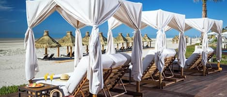 On the beach, white sand, free beach cabanas, beach umbrellas