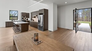 A modern kitchen with dark wood cabinets, stainless steel appliances, and a large island. - Secluded, modern, spectacular views, hot tub on 18 acres. Firepit,games & more! (Sewanee)