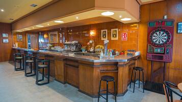 A bar area with a dartboard, bar stools, and a counter with a cash register.
