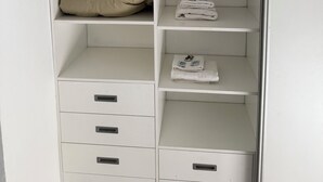 Ein weißer Kleiderschrank mit vielen Regalen und Schubladen.