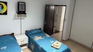 Ein Schlafzimmer mit zwei Betten, einem Kleiderschrank, einem Fernseher und einem Spiegel.