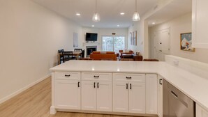 A spacious kitchen with white cabinetry, a central island, and pendant lighting.