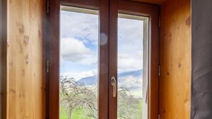 A wooden room with a window overlooking a landscape. - LA MILONGA - AYN - Gîte (AYN)