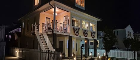 A two-story house with a balcony, a staircase, and a fenced yard.