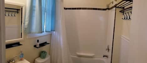 Un baño con inodoro, lavamanos y zona de ducha.