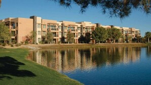 A modern hotel with multiple buildings, a lake, and surrounding greenery. - Awesome Marriott property with many amenities. Sleeps 8. Near Coachella! (Palm Desert)