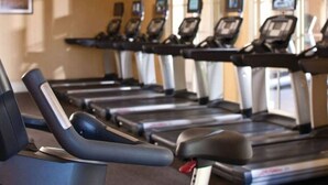 A row of treadmills in a gym with a neutral wall and windows in the background. - Awesome Marriott property with many amenities. Sleeps 8. Near Coachella! (Palm Desert)