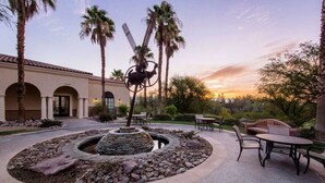 A courtyard with a circular stone fountain, palm trees, and outdoor seating. - Awesome Marriott property with many amenities. Sleeps 8. Near Coachella! (Palm Desert)