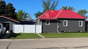 A residential area with a house featuring a red roof and a garage. - 3-bedroom house in tranquil Harvey with WiFi, AC. Relax and unwind (Harvey)