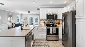 Una cocina moderna con armarios blancos, electrodomésticos de acero inoxidable y una isla grande.
