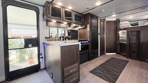 A compact kitchen with a central island, built-in microwave, oven, and cabinets.