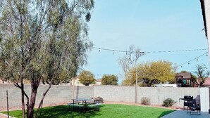Ein Garten mit Rasen, Picknicktisch und Gartenmöbeln.