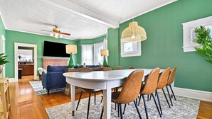 A dining area with a round table, chairs, and a ceiling fan.