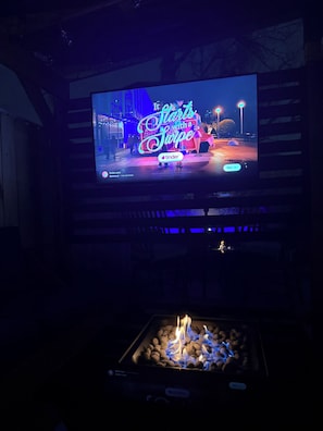 A television displaying an advertisement for Tinder, with a fire feature below it. - Entire Home in St. Roch (New Orleans)
