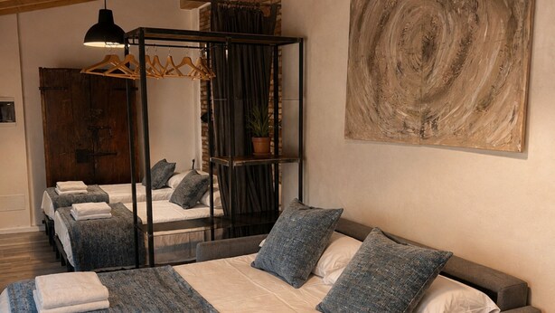 A modern bedroom with a large bed, a hanging light fixture, and a painting on the wall. - Borgovivo Loft A Modern Loft Bergamo City Center (Bergamo)