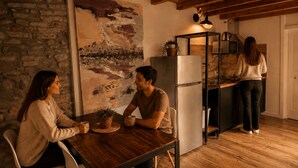 A cozy kitchen with a rustic stone wall, a wooden ceiling, and a modern refrigerator. - Borgovivo Loft B Modern Loft Bergamo City Center (Bergamo)