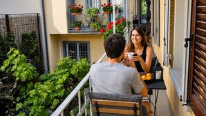 A balcony with a table, chairs, and potted plants. - Borgovivo Loft B Modern Loft Bergamo City Center (Bergamo)