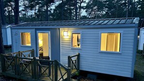 A small cabin with a porch, a door, and a window.