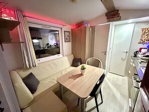 A compact living space with a kitchenette, a dining area, and a sofa.