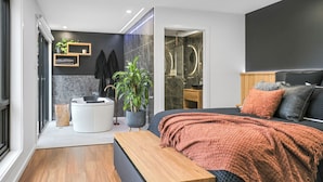 A modern bedroom with a bed, bedside table, and a large window. - Warrawindi Escapes (Penola)