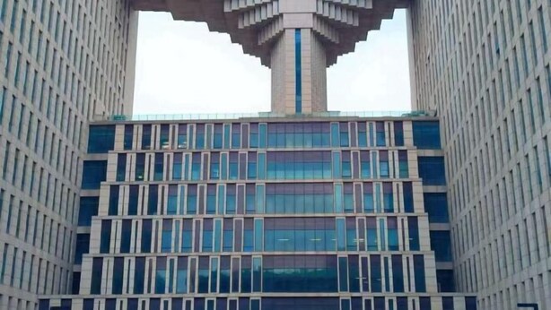 A modern building with a distinctive central tower and a grid of windows. - GreenTree Hotel (Beijing Xueqing Road Xuezhi Garden Subway Station) (Beijing)