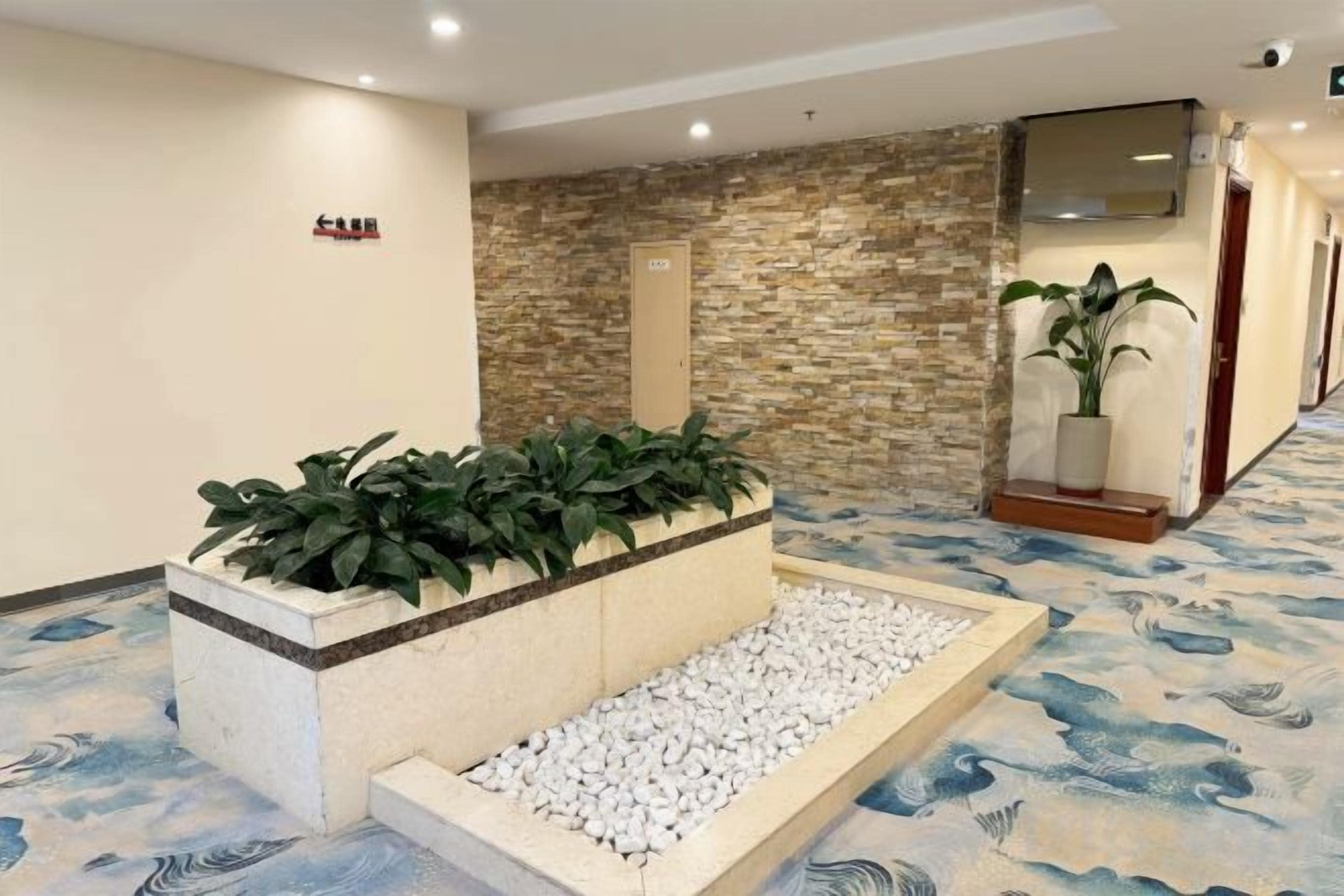 A reception area with a stone wall, a reception desk, and a plant.