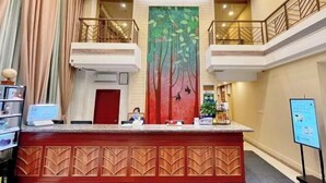 A hotel reception area with a central desk, a large vertical mural, and a staircase leading to an upper level. - GreenTree Hotel (Beijing Xueqing Road Xuezhi Garden Subway Station) (Beijing)