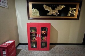 A framed artwork of an eagle on the wall, a red cabinet with glass doors, and a red box on the floor. - Super 8 Hotel (Beijing Qianmen Zhushikou Subway Station) (Beijing)