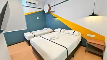 Een hotelkamer met twee bedden, een nachtkastje, een lamp, een airconditioner en een wandplank.
