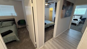 Un apartamento con varias habitaciones, una cama, una silla y un ventilador de techo.