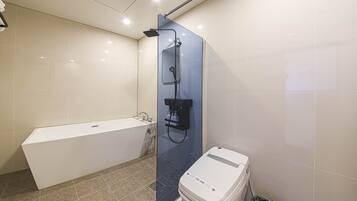 Een moderne badkamer met een bad, een douchecabine van glas en een toilet.